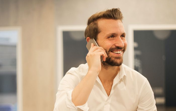 Image shows a man in a shirt, in the office using his phone to demonstrate Triggerpoint's software for surveyors